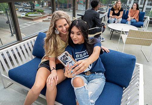 Students sit and take a picture on a bench at Augusta University.